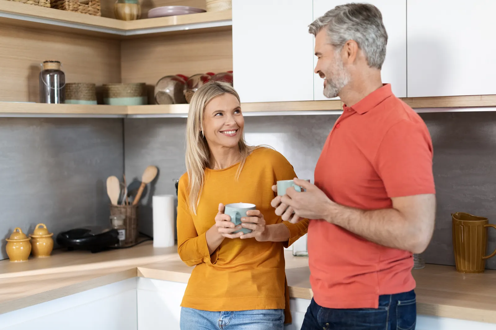 Couple talking over coffee in their kitchen