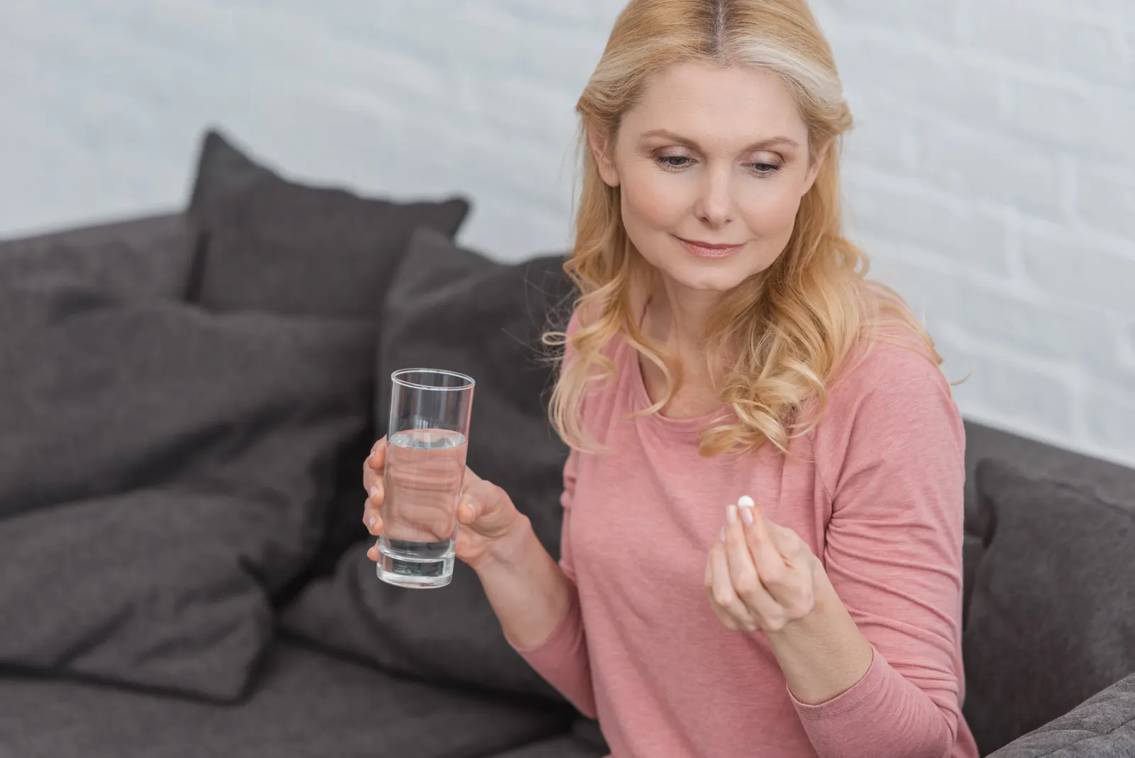 Woman holding a tablet and a glass of water